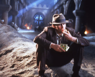 Peter Weller sitzt als Bill Lee auf einem Sandhaufen in einem Hof in Tanger in Naked Lunch.