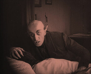 Der schaurige Vampir beugt sich über eine schlafende Person in ihrem Bett.