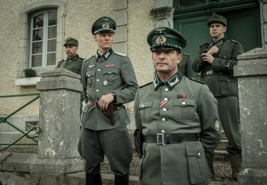 Leutnant Weissmann, gespielt von Tómas Lemarquis, und der Korporal, gespielt von Thomas Kretschmann, stehen in Nur ein einziges Leben vor dem deutschen Hauptquartier im Dorf. 