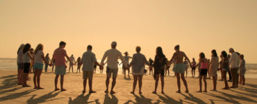 Eine große Gruppe von Bewohnern bilden eine Menschenkette am Strandder Outer Banks