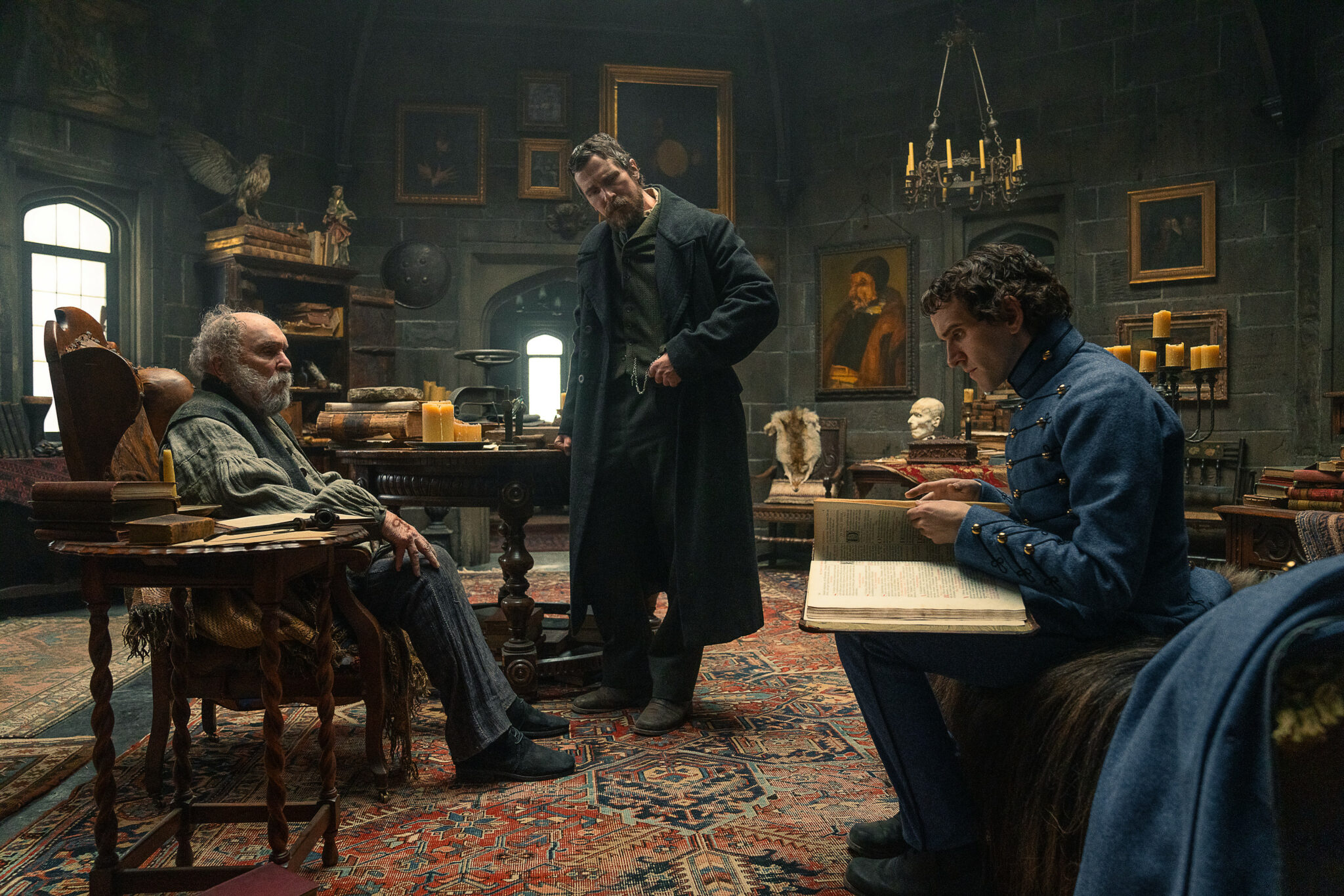 Robert Duvall als Jean Pepe, Christian Bale als Augustus Landor und Harry Melling als Edgar Allen Poe in einem altehrwürdigen Arbeitszimmer.