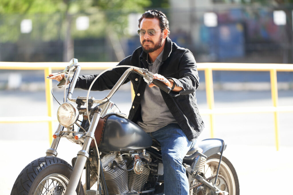 Becker, gespielt von Cole Hauser, ist auf dem Motorrad unterwegs.
