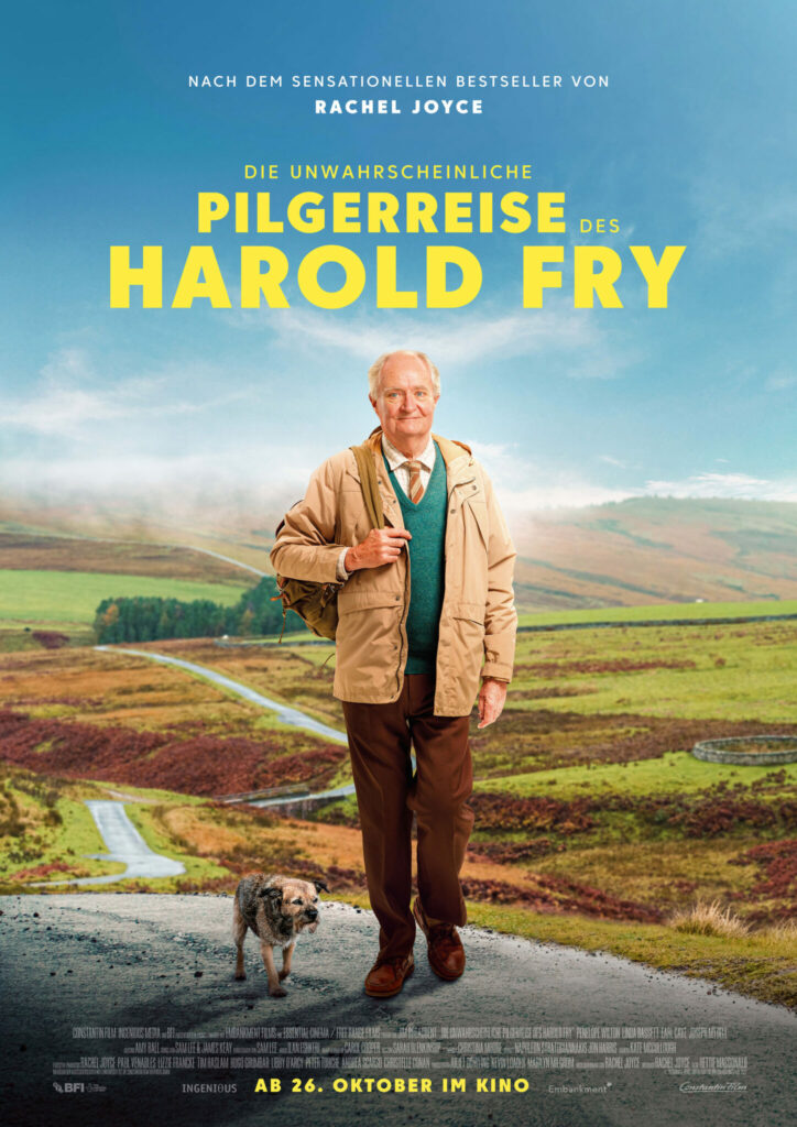 Das Plakat von Die unwahrscheinliche Pilgerreise des Harold Fry zeigt Harold, gespielt von Jim Broadbent, bei seiner Wanderung über eine schmale Landstraße, zeitweilig begleitet von einem kleinen Hund.