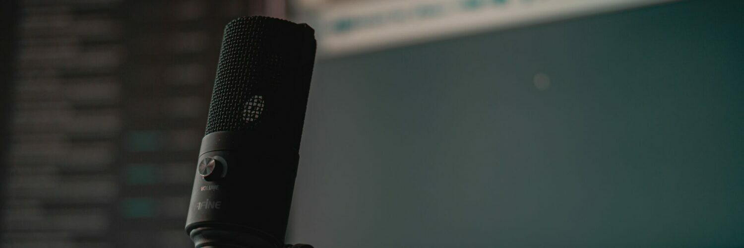 Ein schwarzes Mikrofon vor einem leeren Computermonitor - "An jedem verdammten Sonntag Podcast"