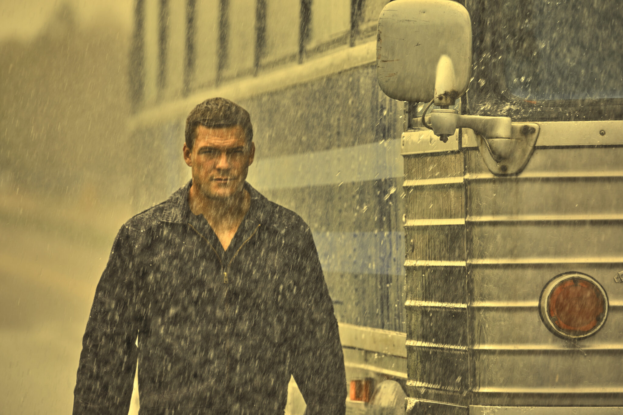 Jack Reacher steht im Regen neben einem Bus. Serien 2022 - Die Neustarts