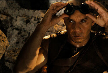 Riddick (Vin Diesel) setzt seine Fähigkeit im Dunkeln zu sehen ein. Er zieht dazu seine Brille ab und blickt einfach mit seien speziellen Augen in die Dunkelheit. - Riddick-Podcast