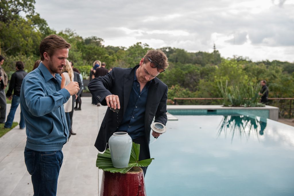 BV (Ryan Gosling) und Cook (Michael Fassbender) stoßen auf den Gastgeber an, in Song to Song von ©Studiocanal Filmverleih. Alle Rechte vorbehalten.