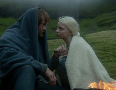 Amleth und Olga am Feuer draußen auf Island, schauen sich verliebt an