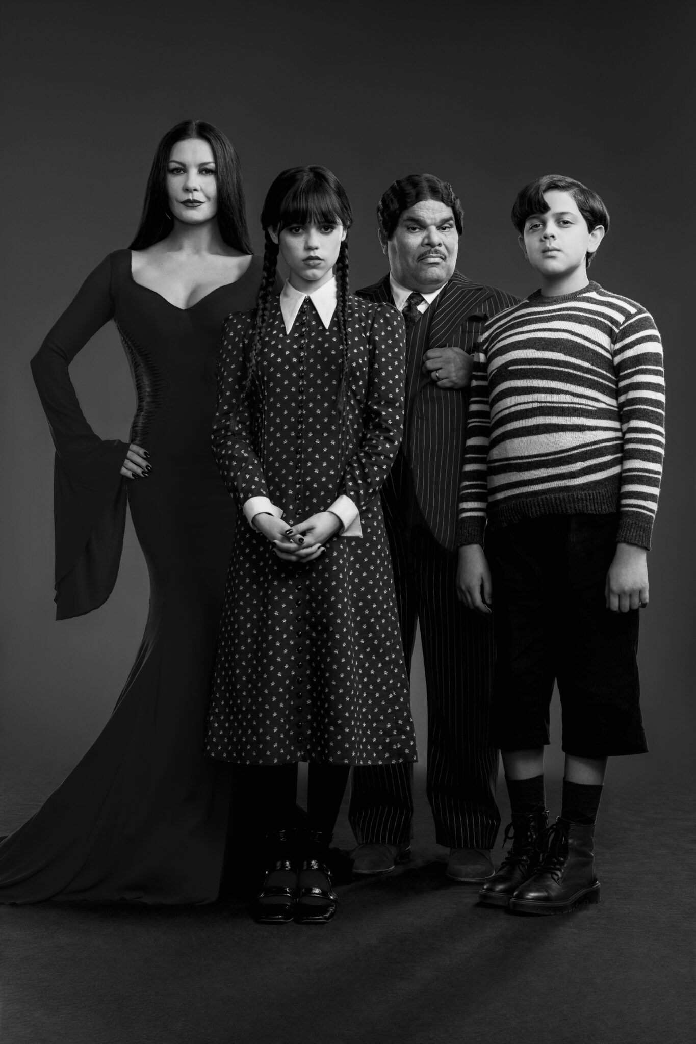 Catherine Zeta-Jones als Morticia Adams, Jenna Ortega als Wednesday Addams, Luis Guzman als Gomez Addams und Issac Ordonez als Pugsley Addams in schwarzweiß