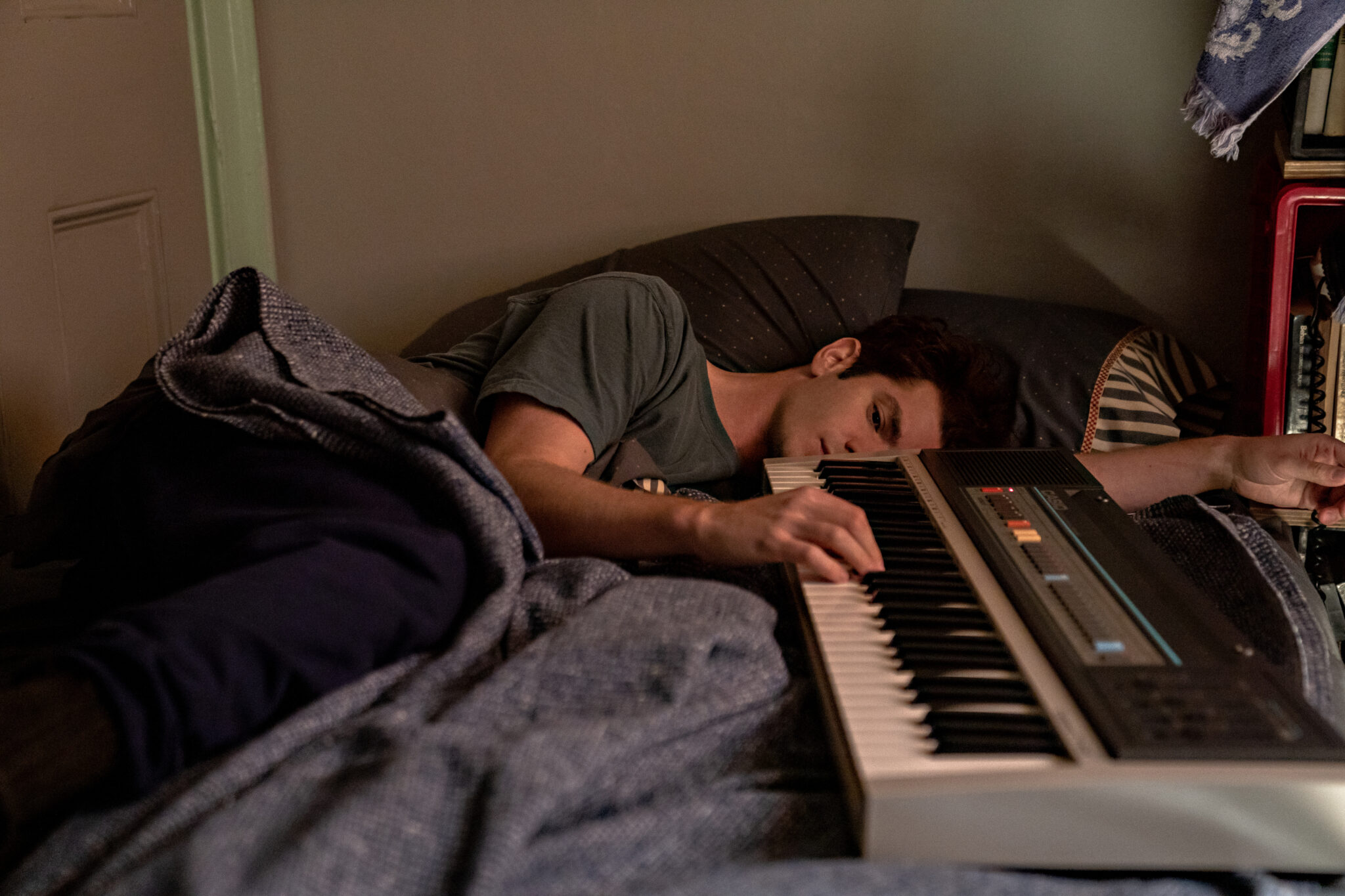 Andrew Garfield liegt im Bett und hält währenddessen ein Keyboard in den Händen. Tick, Tick... BOOM!