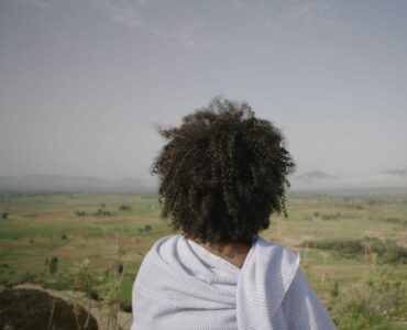Die Kamera positioniert sich hinter Modja, die von einer erhöhten Position auf die Landschaft und die titelgebende Great Green Wall blickt.