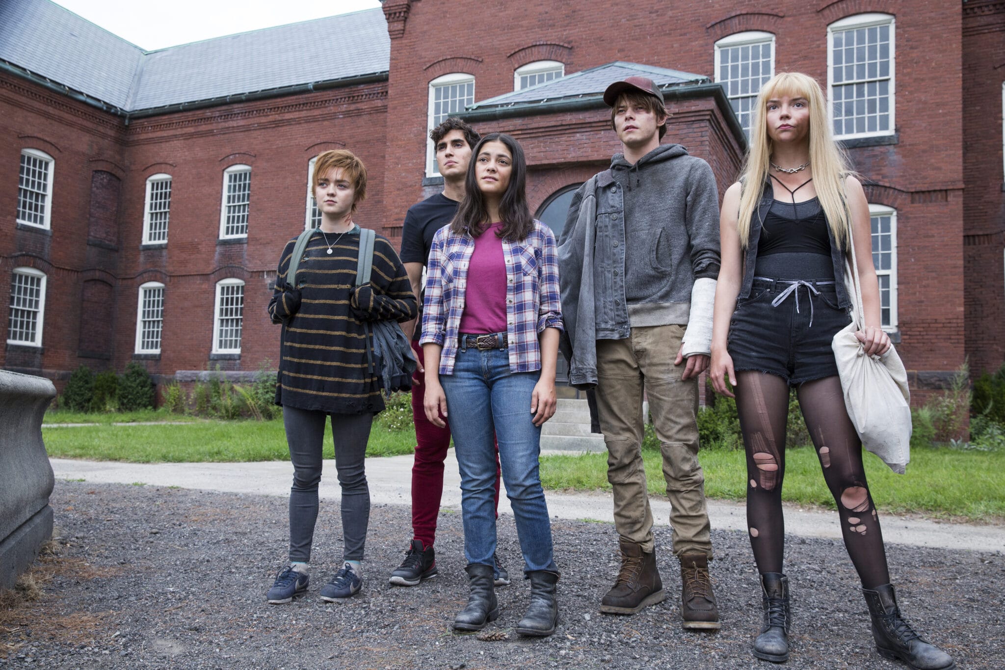 Maisie Williams als Rahne, Henry Zaga als Bobby, Blu Hunt als Dani, Charlie Heaton als Sam und Anya Taylor-Joy als Illyana stehen vor einem Klinikgebäude aus rotbraunen Ziegeln und blicken erwartungsvoll in die Kamera in "The New Mutants".