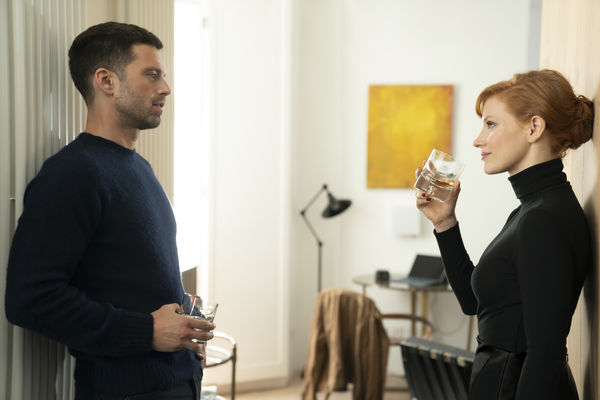 Sebastian Stan und Jessica Chastain stehen sich vielsagend gegenüber, jeder einen Drink in der Hand - The 355.