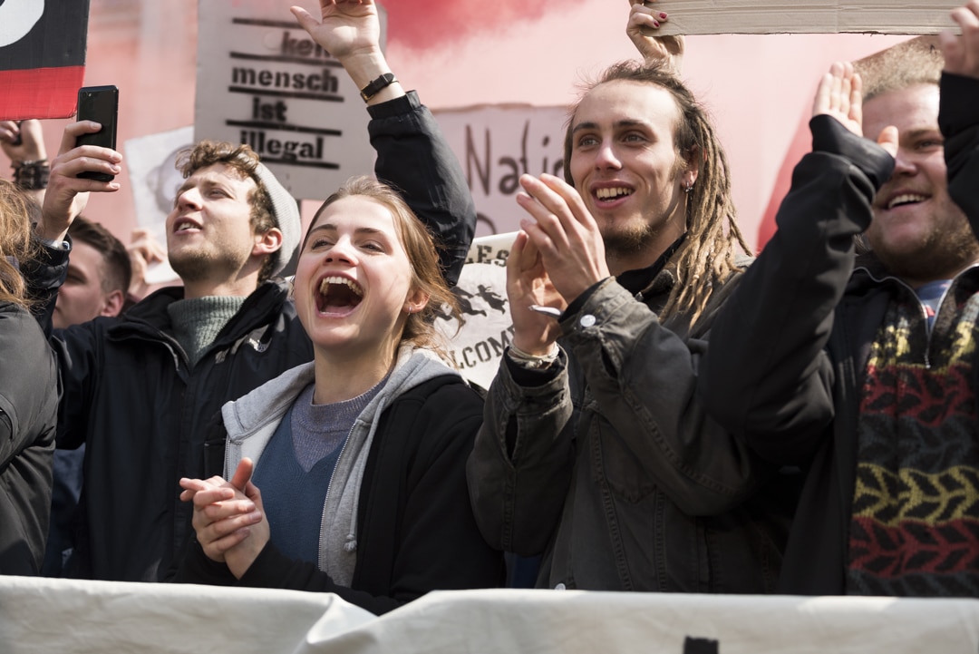 Antifa-Demonstranten demonstrieren klatschend und gröhlend mit Spruchbannern