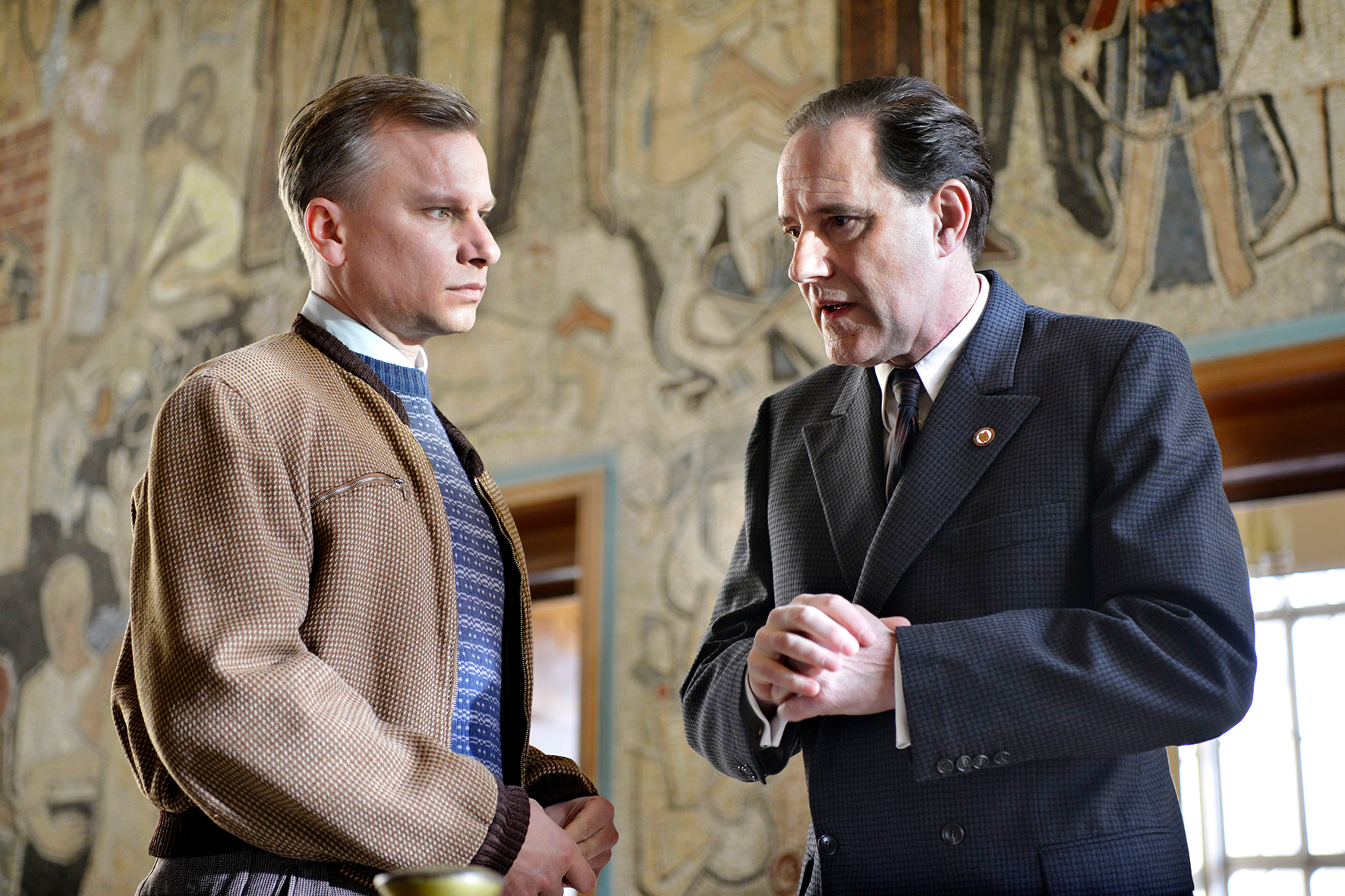 In einem Amtsgebäude stellt der Arzt Konrad Zeidler (Robert Stadlober) den Sekretär für Agitation und Propaganda, Leo Silberstein (Stefan Kurt), zur Rede.