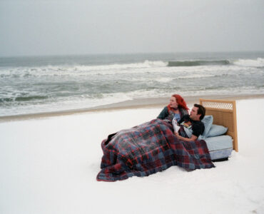 "Vergiss mein nicht" ist ein Beispiel dafür, dass der deutsche Filmtitel sich enorm vom Originaltitel unterscheidet. Auf dem Bild sind Kate Winselt und Jim Carrey zu sehen, die zugedeckt in einem Bett liegen. Dieses Bett befindet sich an einem weißen Strand direkt am Wasser. Die beiden Schauspieler blicken aufs Meer hinaus.