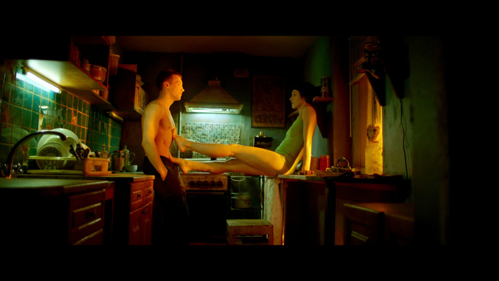 Aleksandr Kuznetsov als Matvey steht in Why Don't You Just Die! mit Olya (Evgeniya Kregzhde), seiner Freundin, in der Küche und erhält von ihr einen mörderischen Auftrag.