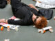 Nan Goldin liegt auf dem Boden eines Museums. Neben ihr liegen leere Medikamentendöschen und Protestplakate