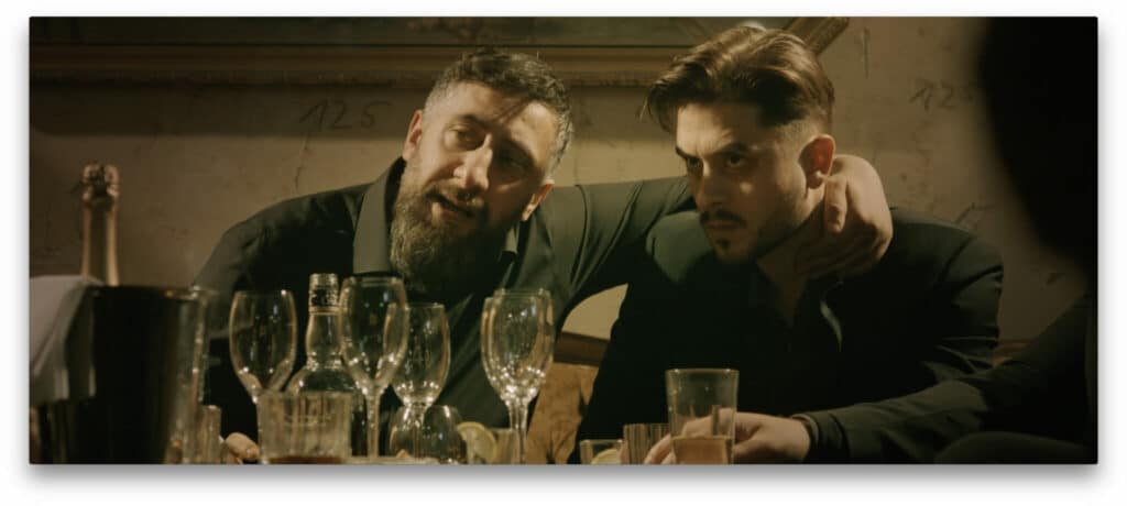 Murat (Kida Khodr Ramadan) und sein Ziehsohn, der Boxer Gabriel Stark (Mehrdad Taheri), sitzen an einem Tisch vor leeren Gläsern