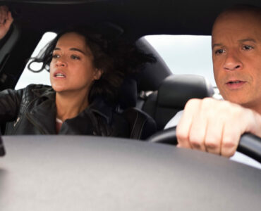 Letty und Dom im Innenraum eines Autos. Dom lenkt während Letty erschrocken aussieht.