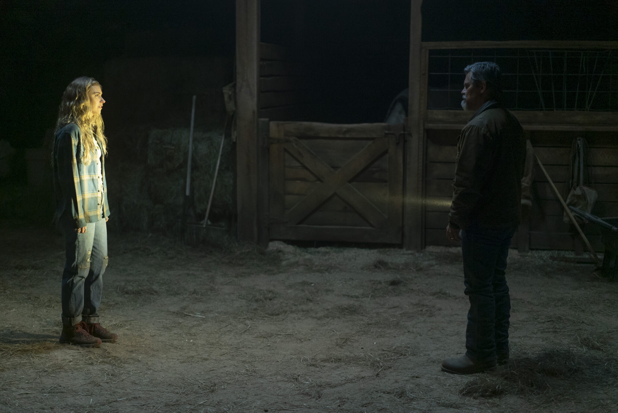 Imogen Poots steht in einer dunklen Scheune vor Josh Brolin, der sie mit einer Lampe anstrahlt.