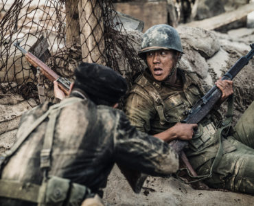 Hinter ihrer Deckung schießt ein Südkoreaner auf die Gegner, während der andere nach Atem schnappt in "Bataillon der Verdammten - Die Schlacht um Jangsari"