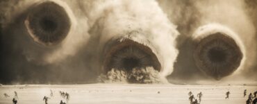 In einer Wüstenlandschaft sind drei gigantische Würmer zu sehen. Eine Szene aus Dune: Part Two.
