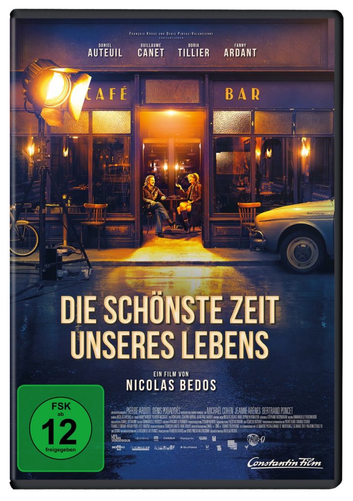 Das DVD-Cover zu "Die schönste Zeit unseres Lebens" mit Titel, FSK-Logo und einer Abbildung des Filmset-Cafés, in dem die beiden Hauptdarsteller sich gegenüber sitzen