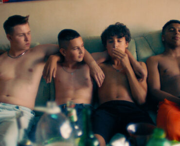 Die vier Hauptfiguren aus Sonne und Beton, Lukas, Julian, Gino und Sanchez sitzen oben ohne auf einem Sofa und rauchen