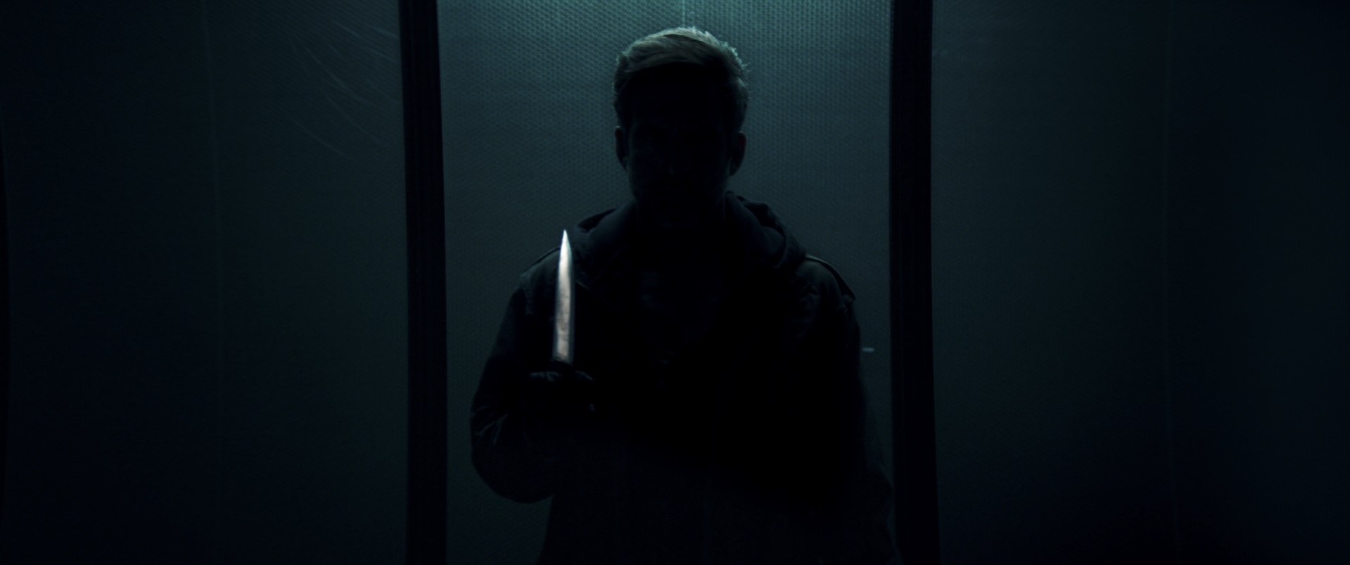 Auf dem Bild erkennt man eine Silhouette des Serienkiller "Der Cellist", wie er vor der Kamera mit einem Messer steht - Dark Glasses 